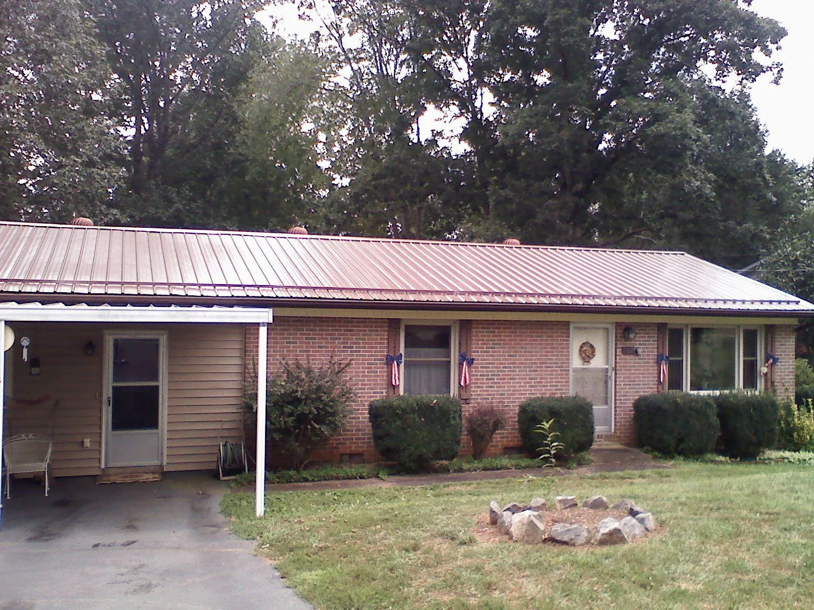 Bronze metal roof and carport on a brick ranch home — Roof Repair work by our crew in Black Diamond